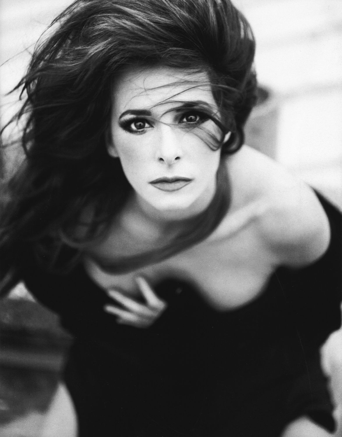 Ritratto ravvicinato in bianco e nero di Mylène Farmer, con lo sguardo rivolto verso l’obiettivo.